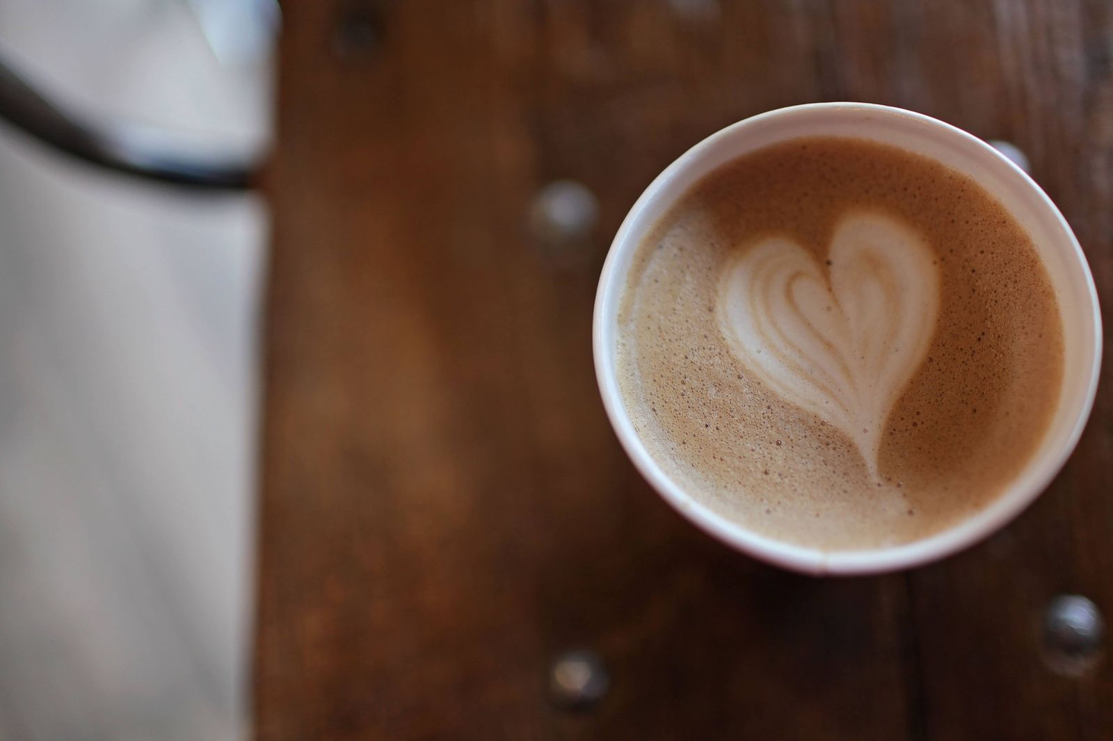 A cappuccino with a clean heart on a wooden table