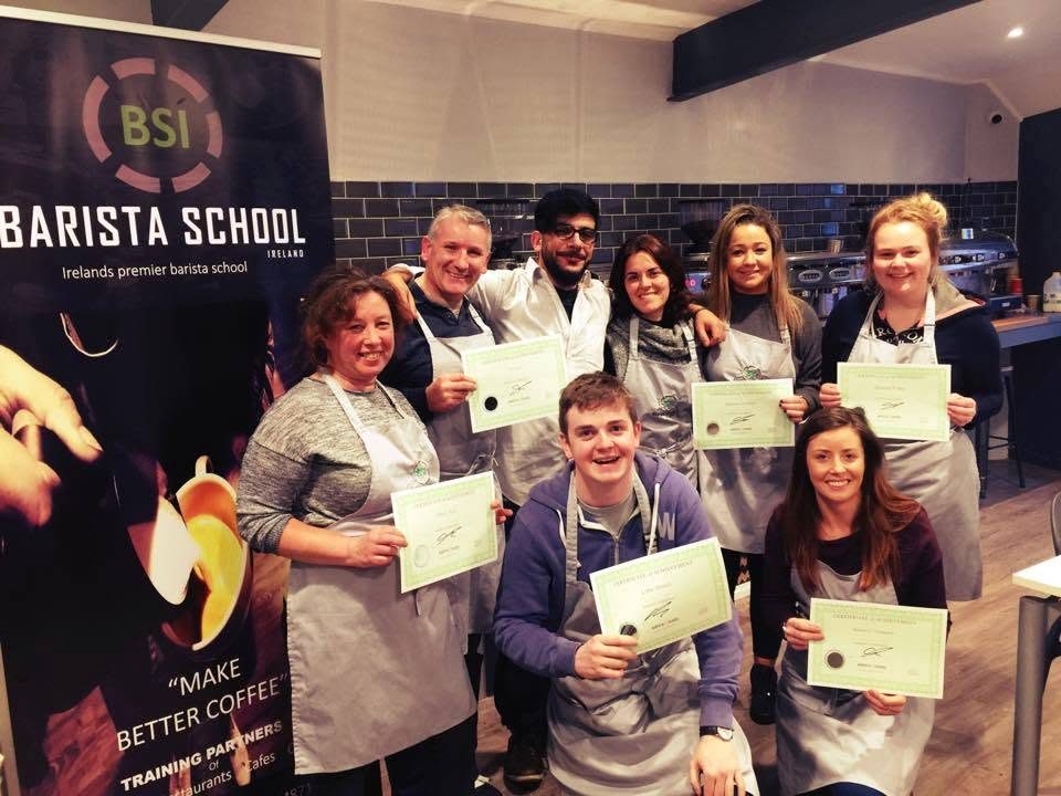 A class of graduates smiling with their certificates