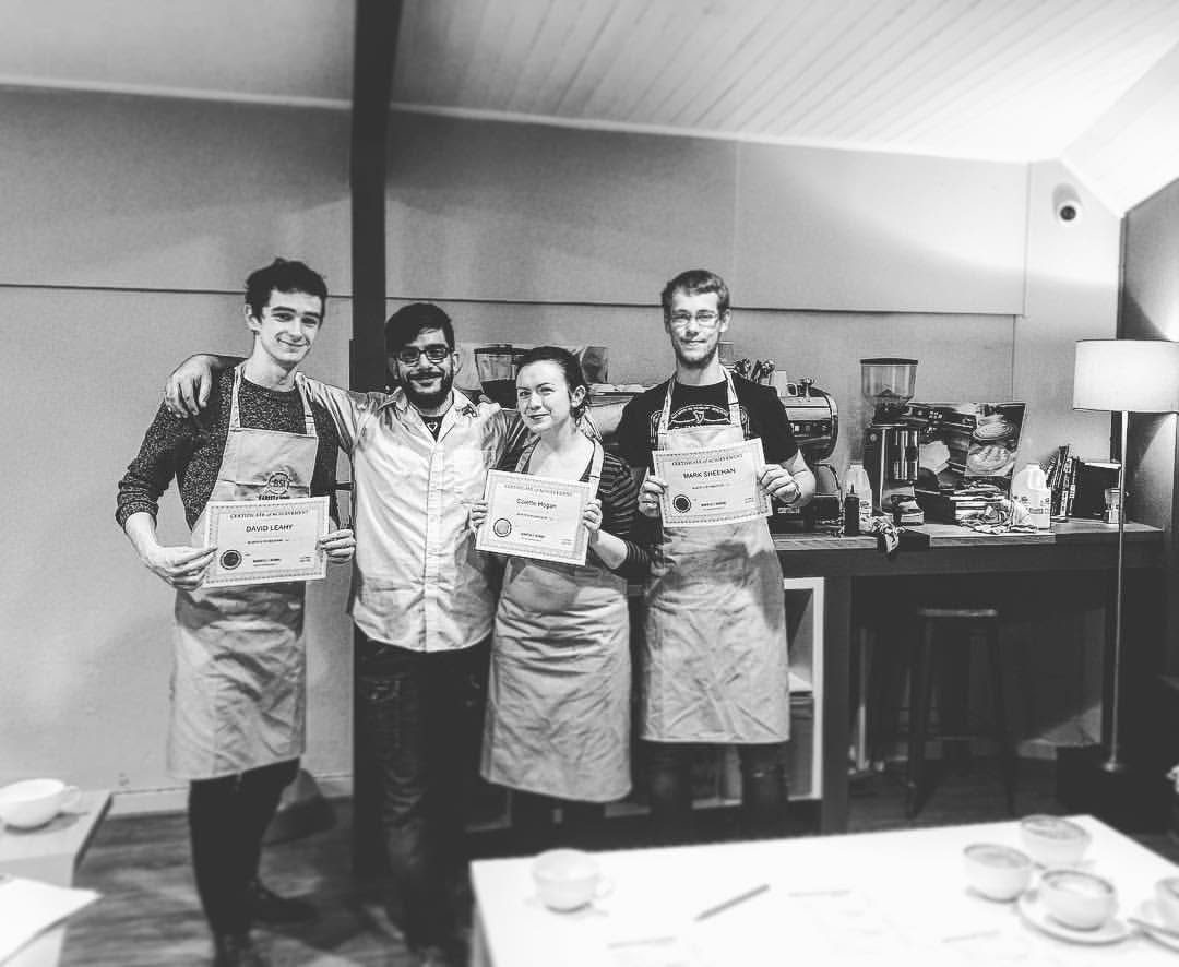 Graduates with their certificates at the coffee bar