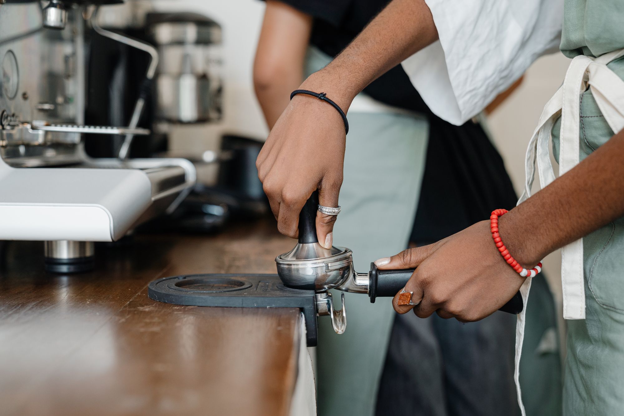 A barista tamping espresso at the machine